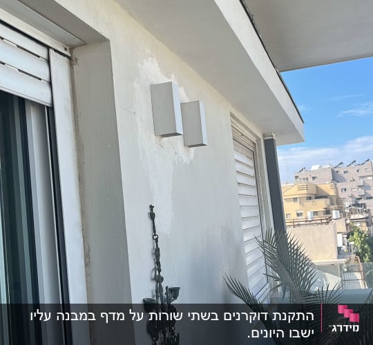 מרפסת עם קיר לבן, עציץ ודקורציה תלויה
